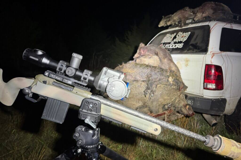 Vortex Pro Rifle Clamp with Savage 110 PPR and Pulsar Thermion 2 LRF  XL60 in the dark with pile of wild hogs and white hunting truck