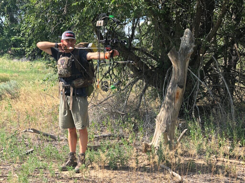 man shooting compound bow
