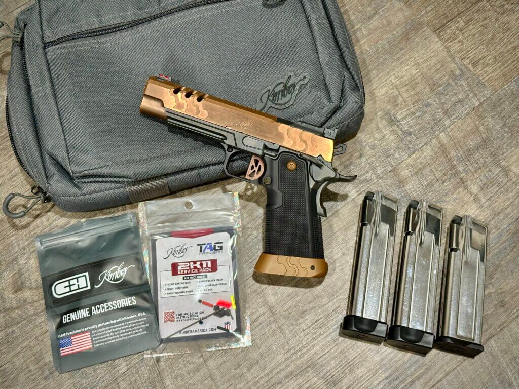A bronze 2011 pistol is shown with three magazines and optics-mounting hardware