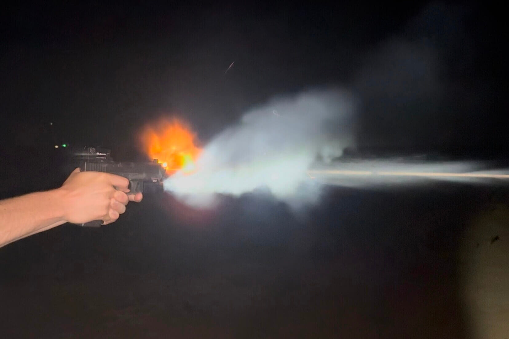 person shooting pistol at night
