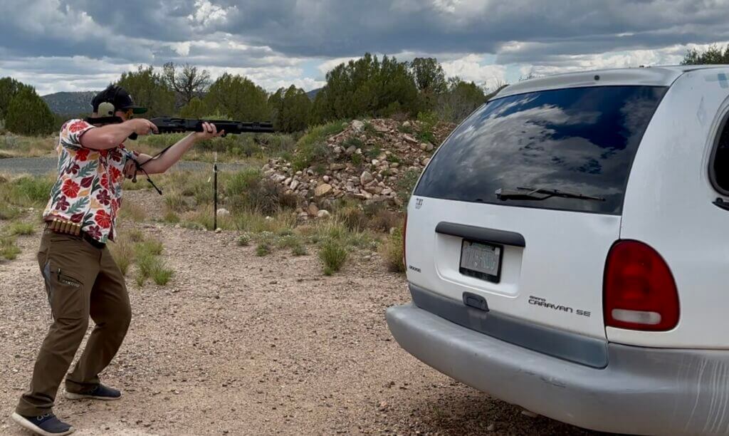 A man in a Hawaiian shirt is shooting the 940 Pro Tactical SPX from beside a van.