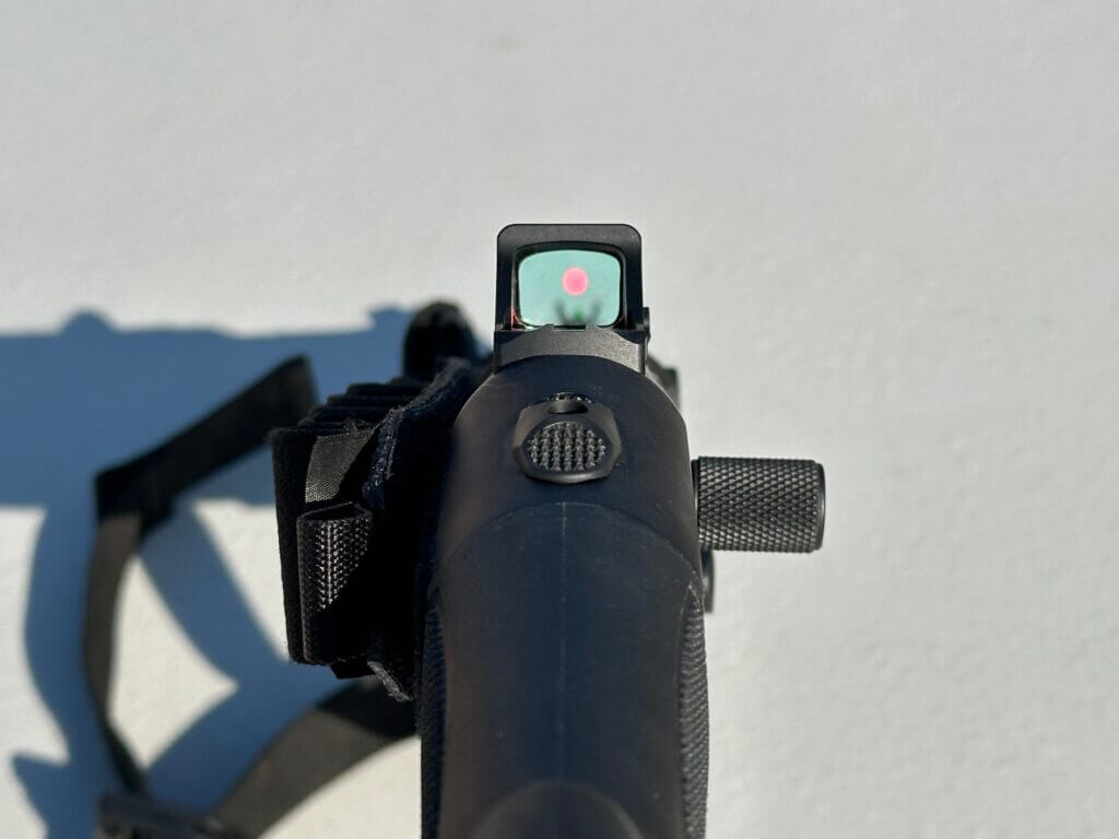 looking down the sights of a shotgun with a red dot optic mounted. 
