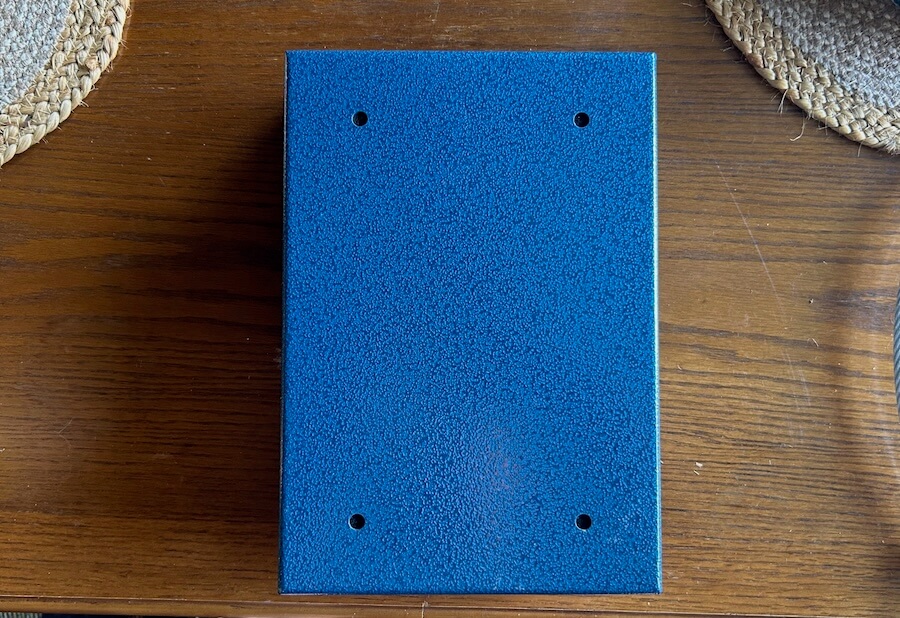 Underside of pistol lock box showing four pre-drilled mounting holes.