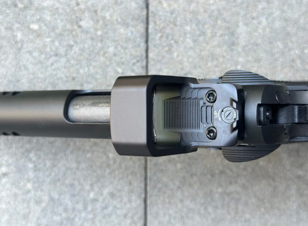 Top-down closeup view of a red dot optic mounted on a pistol. MAX