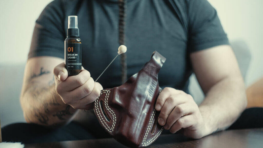 Applying denatured alcohol to a leather holster for proper break-in.