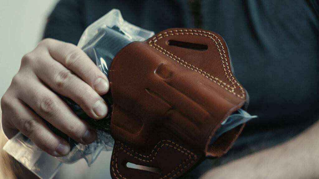 Pistol placed in plastic bag for breaking in a leather holster.
