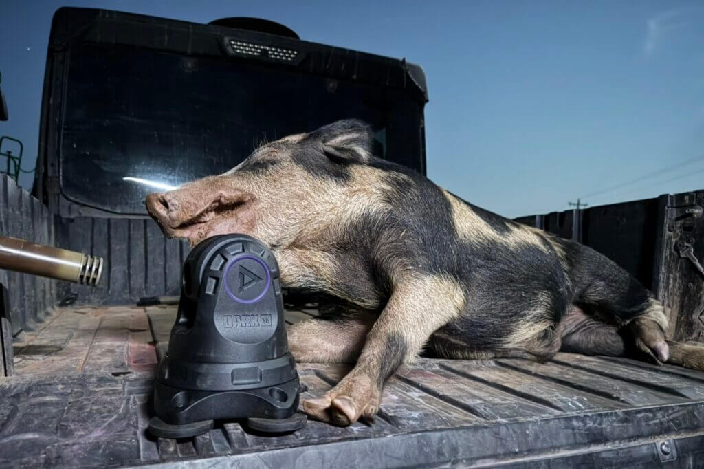 Dark 30 Defiance PTZ set beside harvested pig located at night in cotton field