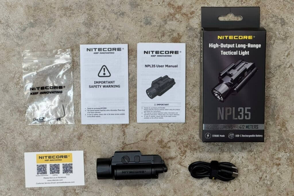 Nitecore NPL35 pistol light in the box with charging cable manual and mounting hardware