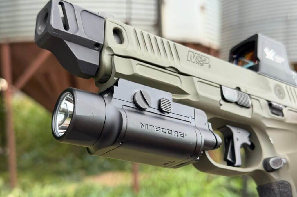 Nitecore NPL35 mounted on a pistol showing the compact rail-mounted weapon light profile
