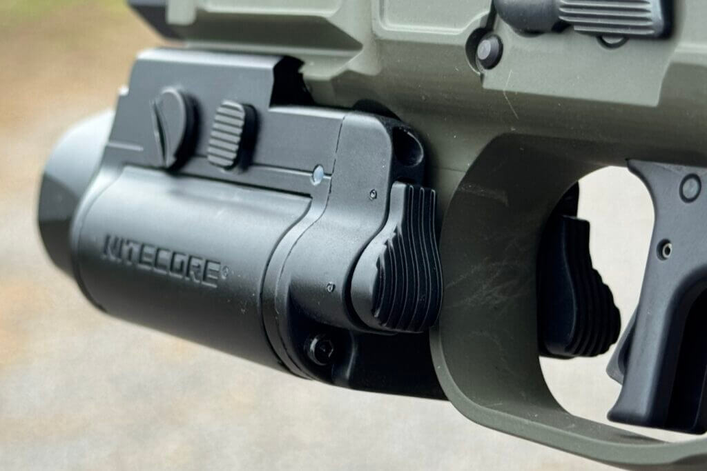 Rear controls and side rail adjustment button on the Nitecore NPL35 pistol light