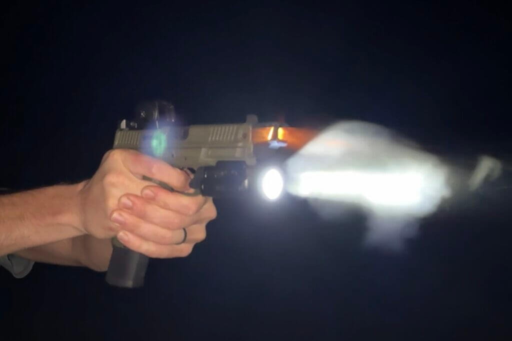 Pistol with Nitecore NPL35 on a dark range during after-dark live fire testing