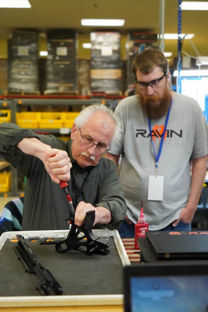 Author assembling Ravin R470 with technician guidance at factory event