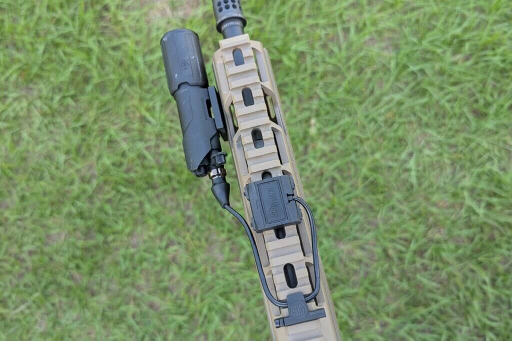 Rifle with offset light and pressure switch routed along handguard