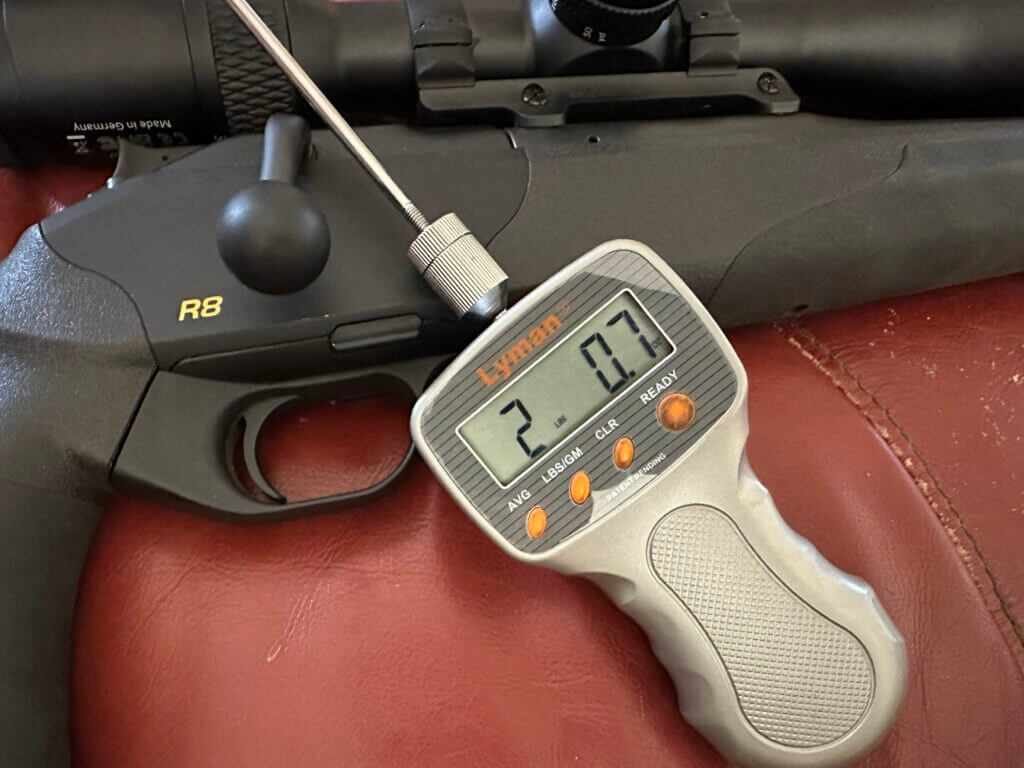 Blaser R8 trigger closeup with Lyman trigger gauge reading two pounds