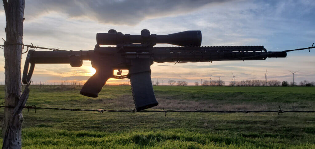 AR-15 in .223 Remington resting on fence for small game and varmint hunting