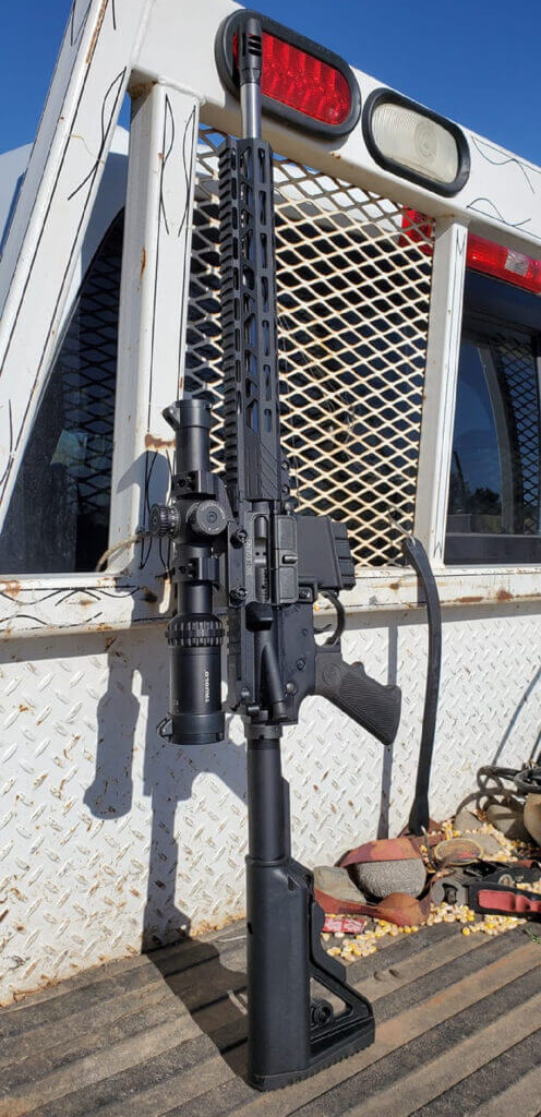 AR-15 chambered in 350 Legend leaning on a truck for straight-wall cartridge hunting