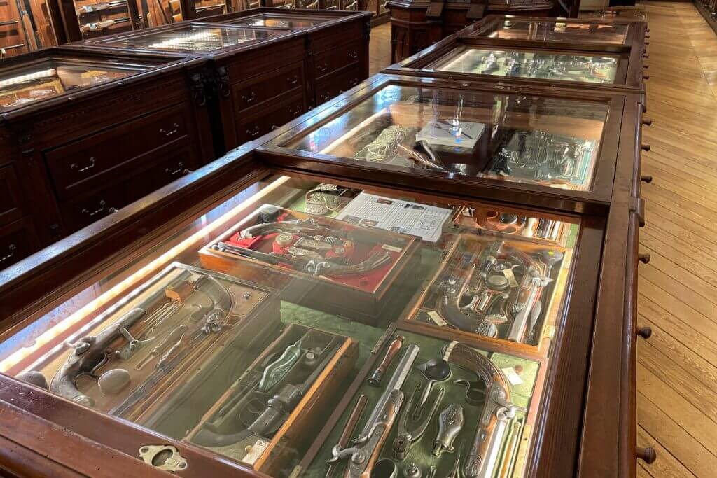 Beretta gun cabinets packed with historic pistols rifles and pull out drawers