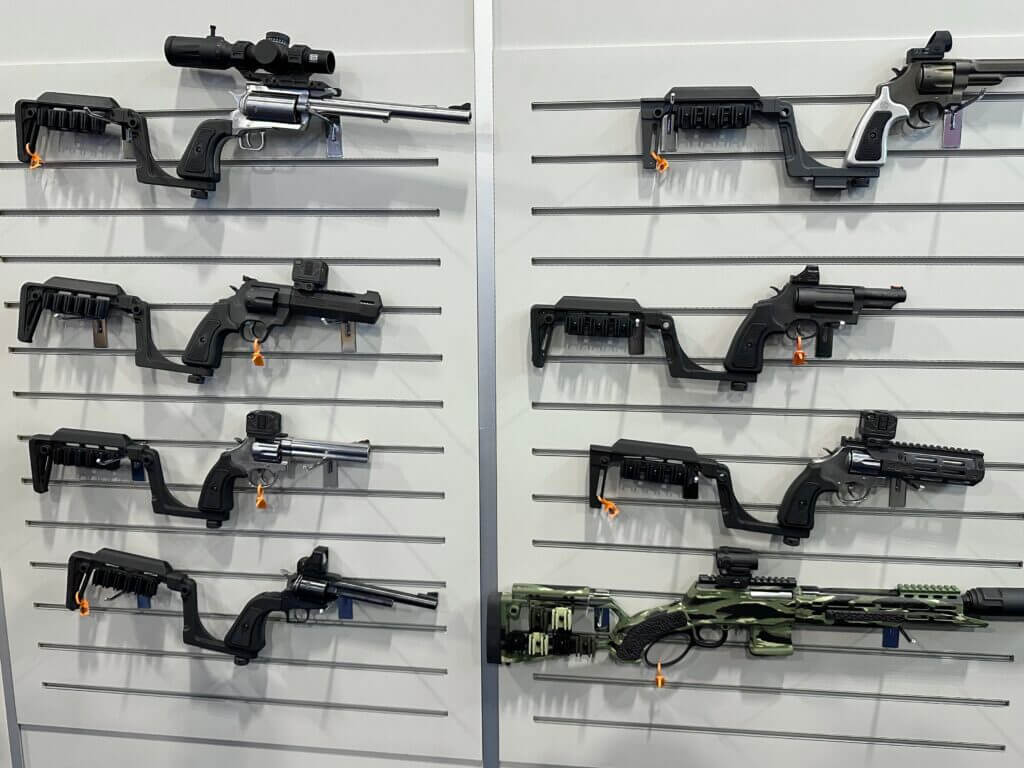 A wall is covered with pistols hanging on hooks. Each has the attachable Bounty Hunter Series stock or brace.