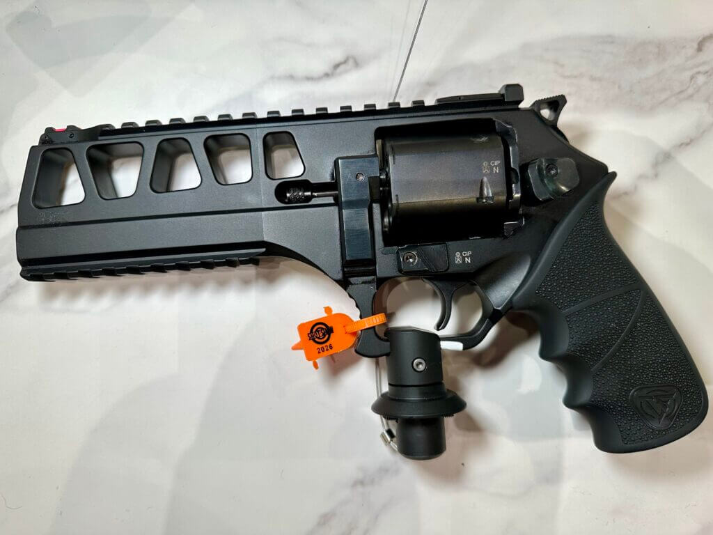 Left side of the Chiappa revolver on display. The black gun is laying on a white granite countertop.