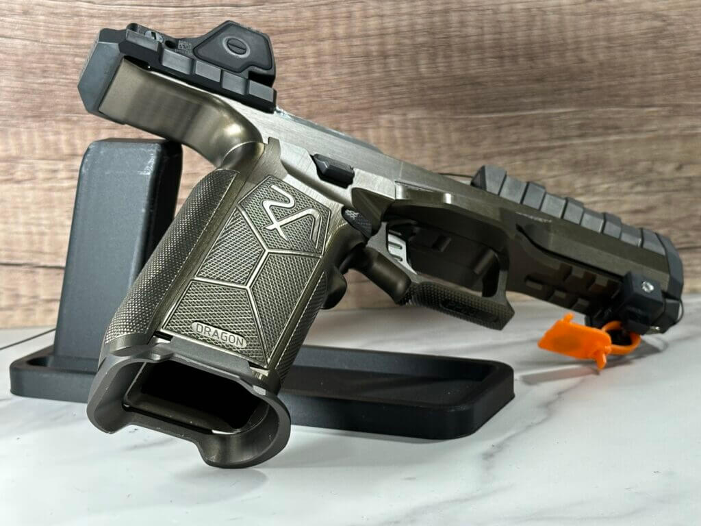 There is a pistol resting on a display stand, pointing away to show the inside of the magazine well.