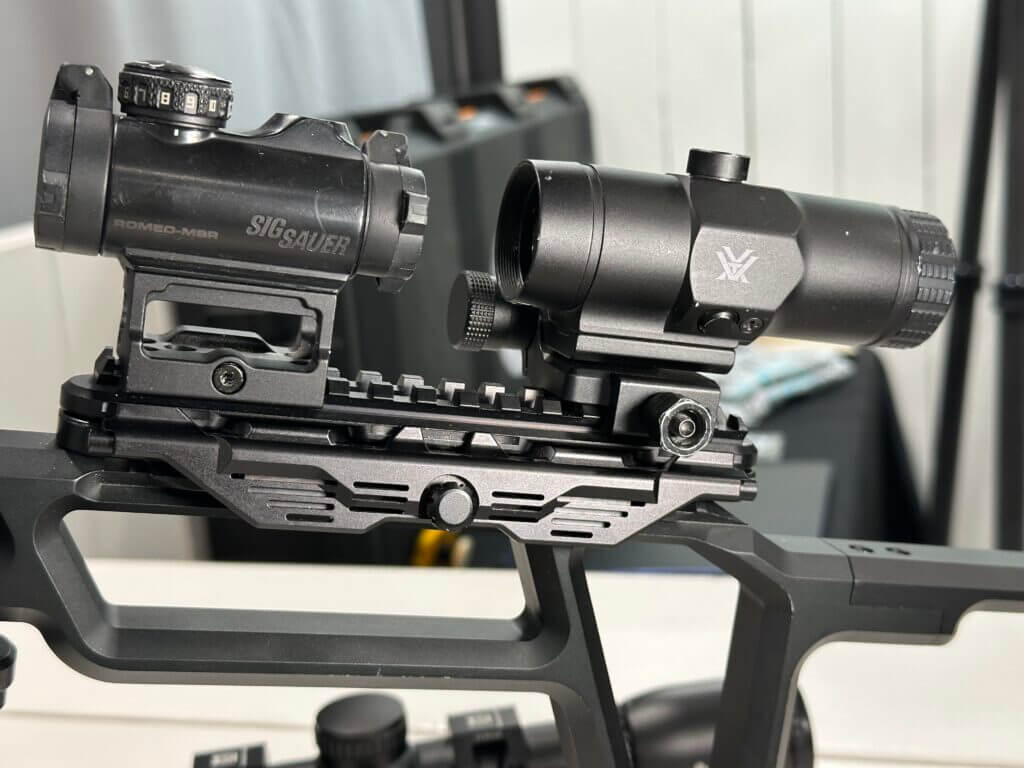 The optic mount on this display firearm now has a red dot and magnifier attached to it.