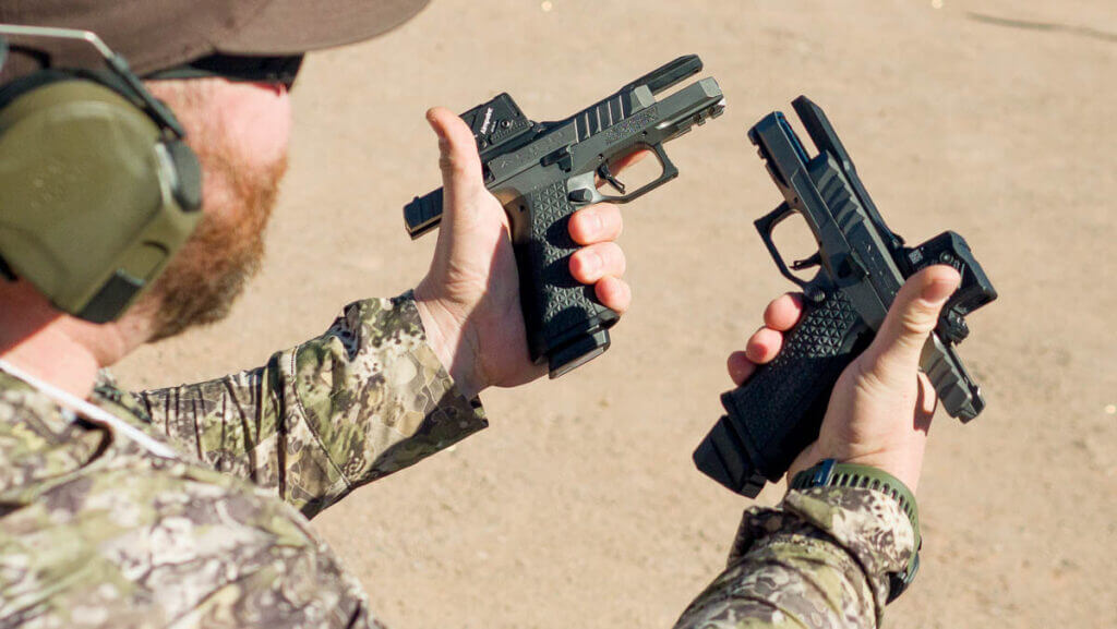 Close up of left- and right-handed pistols in a shooter's hands at the range.