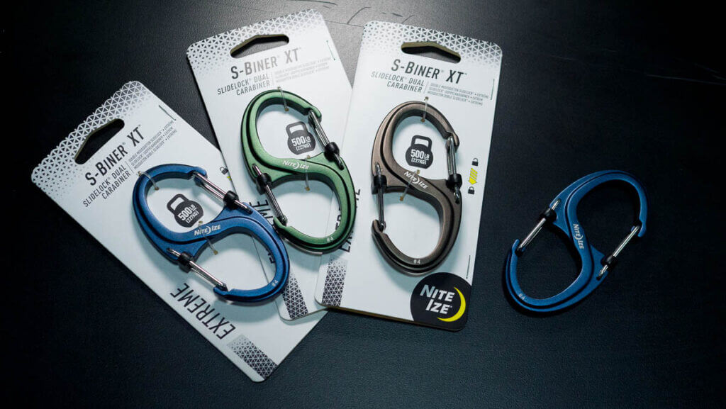 4 of the product lying on a black table, three of them in packaging.