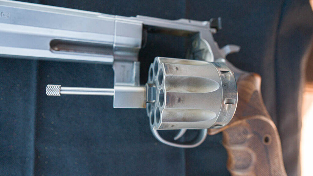 Close up view of the open cylinder with the gun lying on the table.