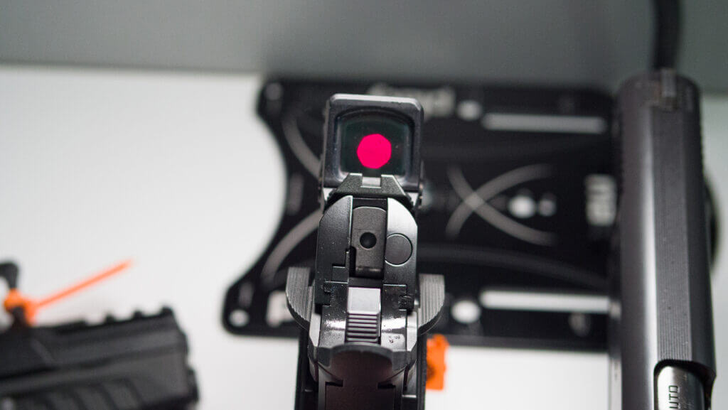 Looking at the back of the gun with the red dot illuminated in the optic.