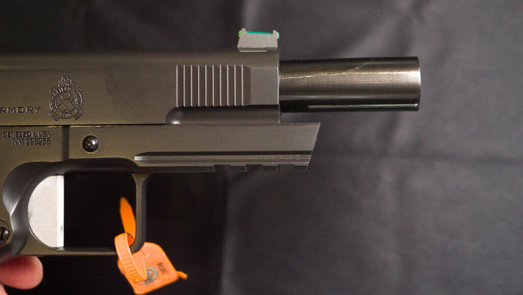 Close up view of the end of the barrel on the right side with the slide retracted.