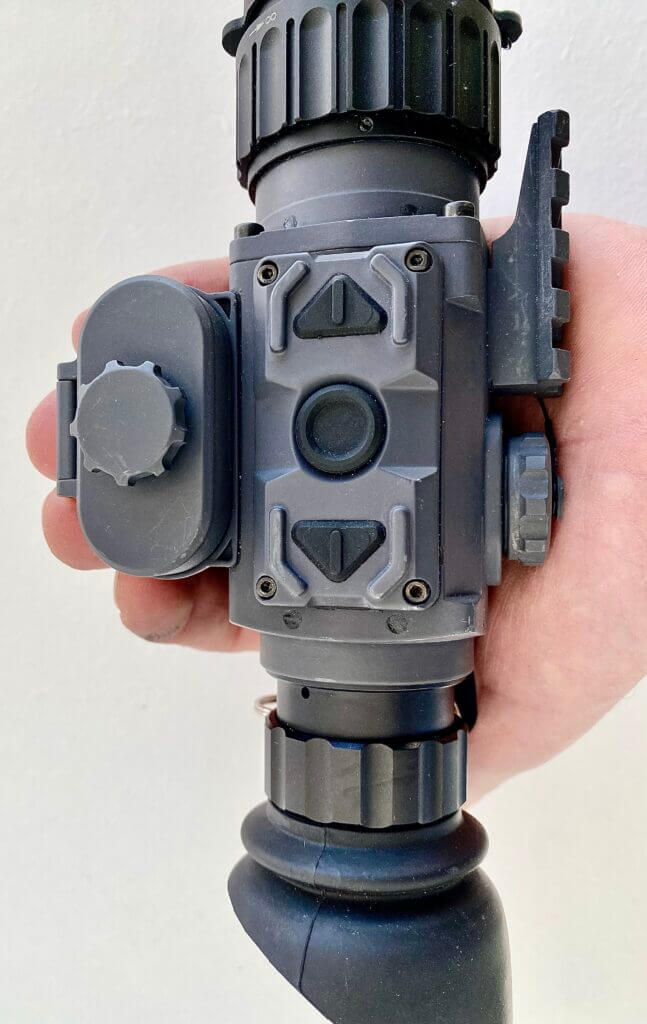 Armasight Warden 640 thermal monocular in hand showing three-button controls and battery compartment