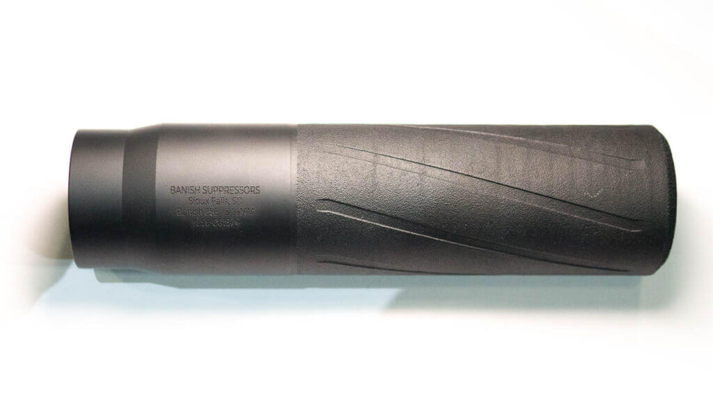 The supressor laying flat on a table pointing right.