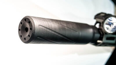 Close up of the end of the suppressor with it attached to a rifle.