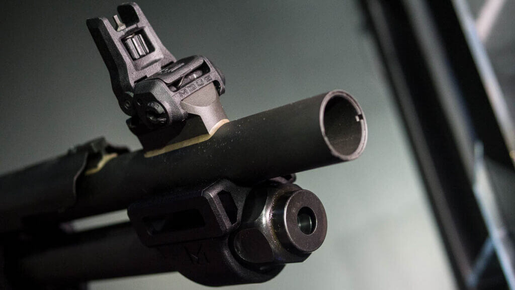 CLose up view of the end of the barrel, magazine, and sight.