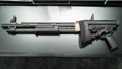 The whole gun with the stocked folded sitting on a table pointing to the left.