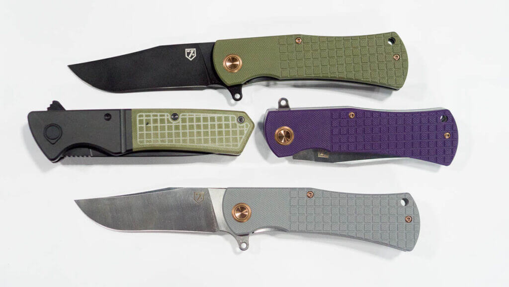 four blades laying on a table, two of them are folded, two are open.