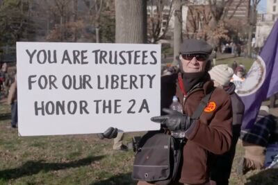 A man holding up a pro-2A sign.