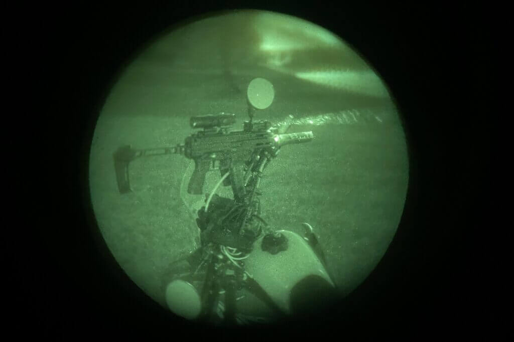Holosun IRIS-3 mounted on a rifle outdoors showing compact low-profile laser and illuminator setup