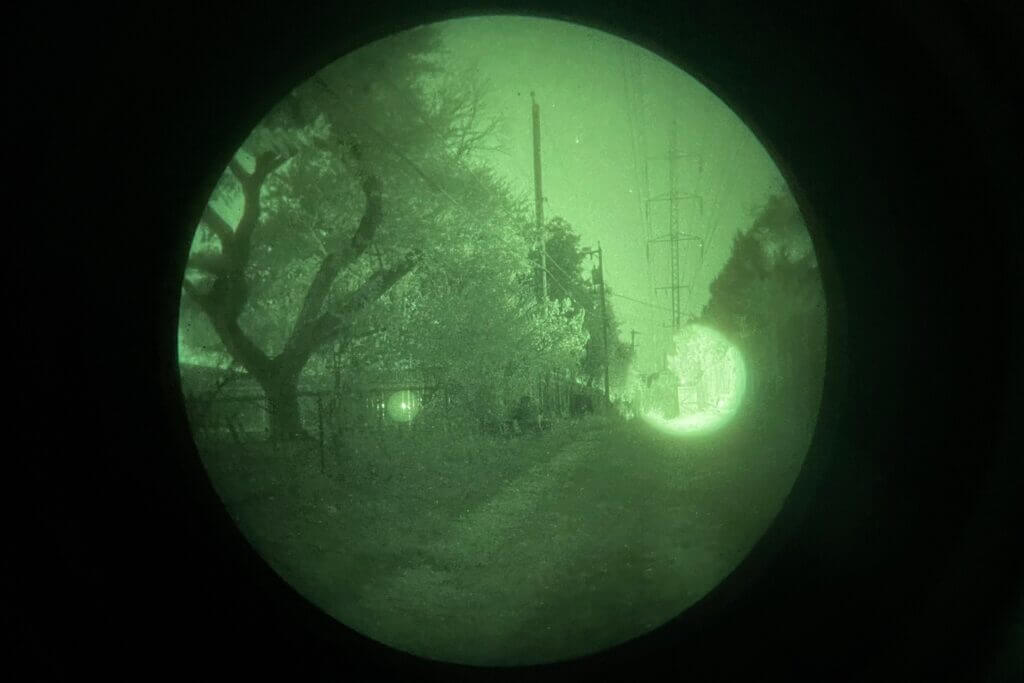 Holosun IRIS-3 aiming laser visible in an urban night environment with ambient light