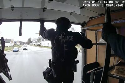 A police officer in the back of a raid rig.