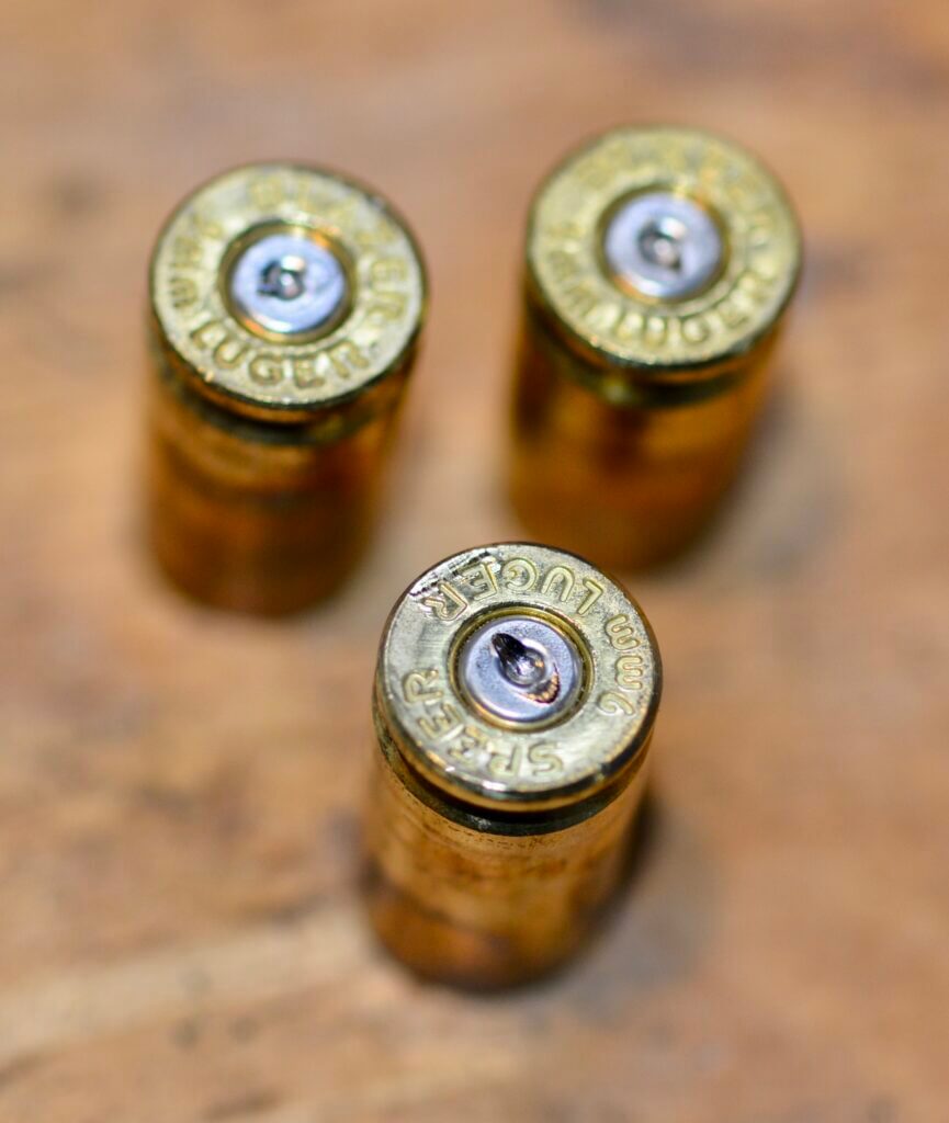 Microstamping guns title image showing spent brass and firearm evidence concerns