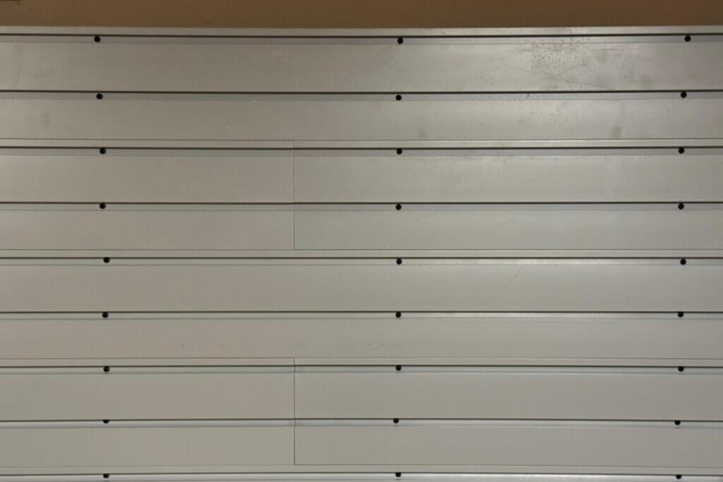 Visible screw heads in Hold Up Displays Gun Wall slats before cosmetic inserts are installed