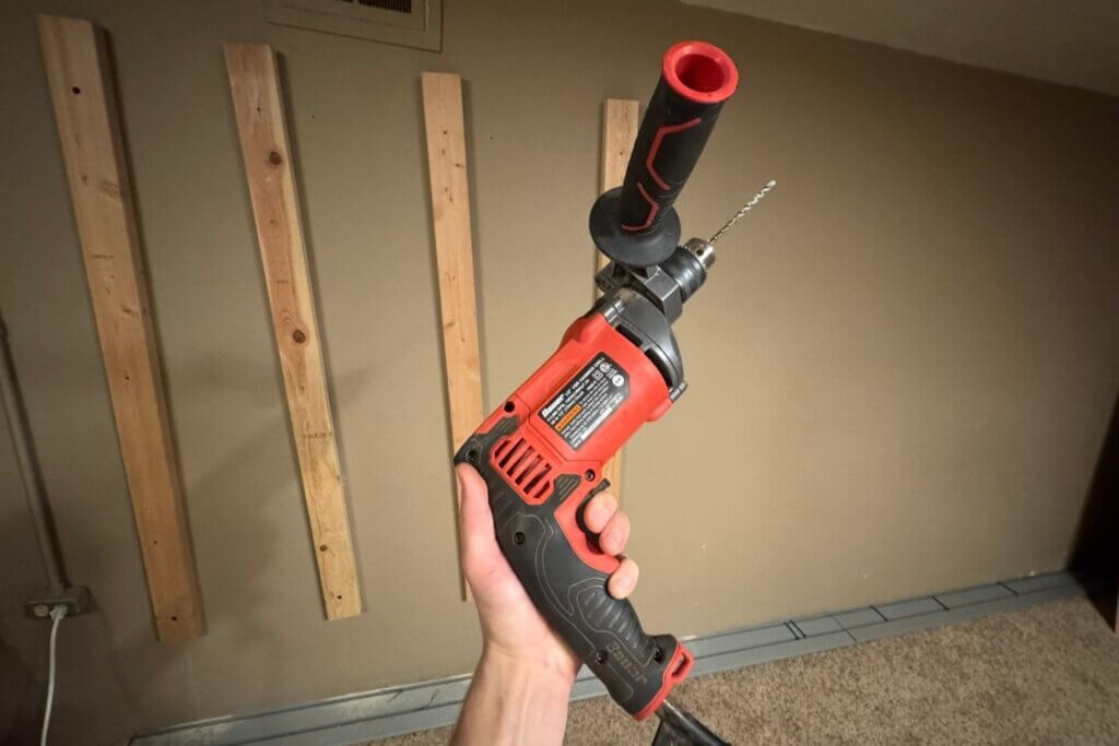 Rotary hammer drill used to mount a Hold Up Displays Gun Wall onto a concrete safe-room wall