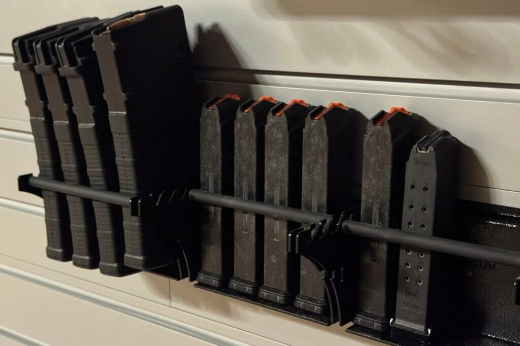 Adjustable Hold Up Displays magazine shelves mounted beneath firearms on the Gun Wall