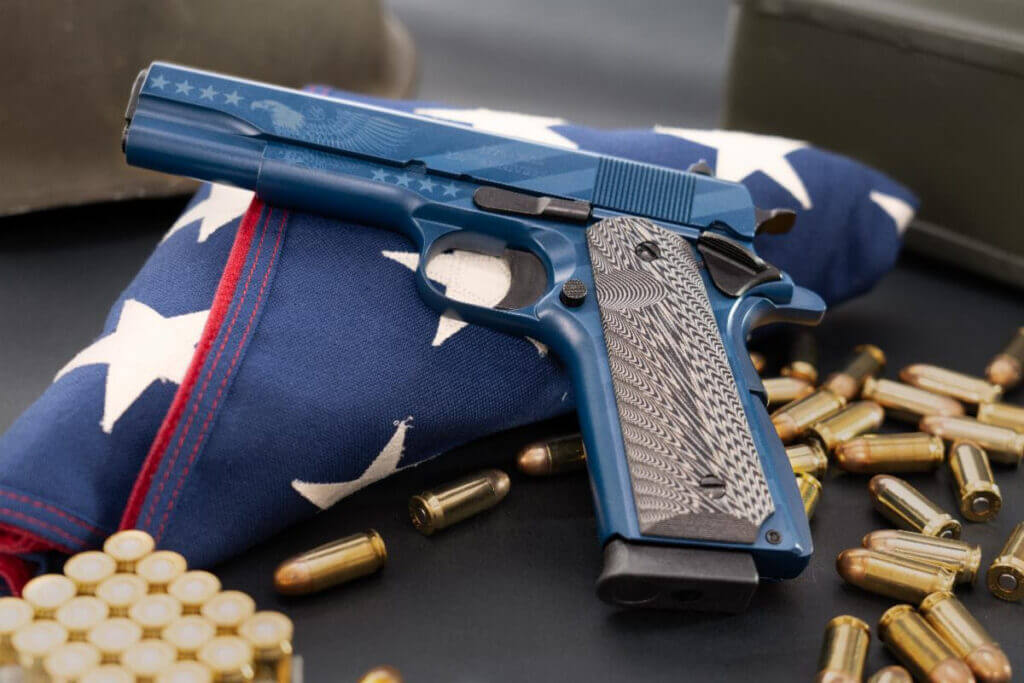 Chiappa 1911 Field Special 250th Independence Edition .45 ACP pistol displayed on a folded American flag with ammunition.