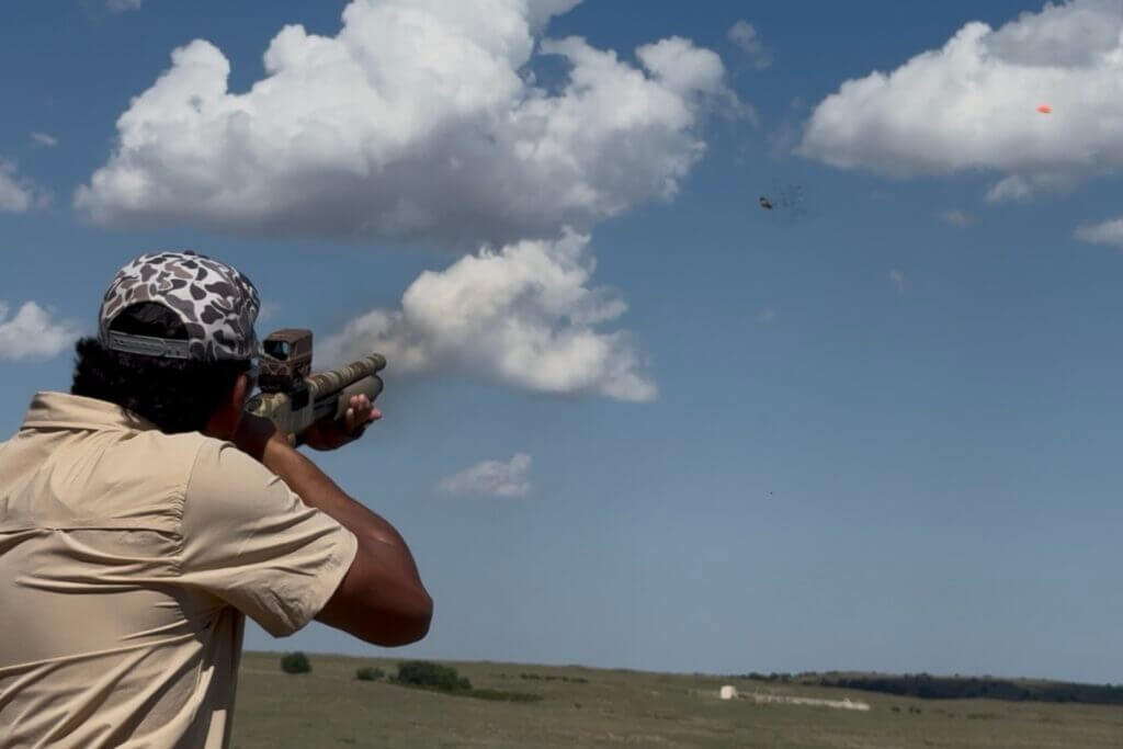 Shooter using the Mossberg 590 Bliksem on clay targets during range testing