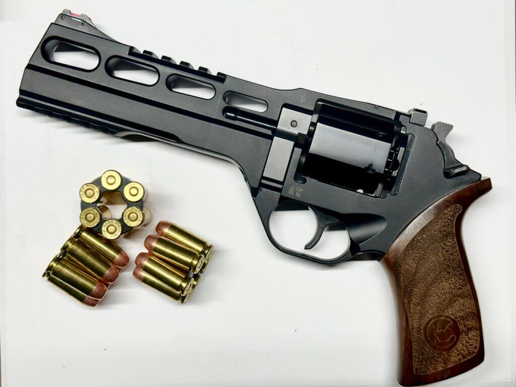 a black handgun with a wooden grip is staged on a white background.