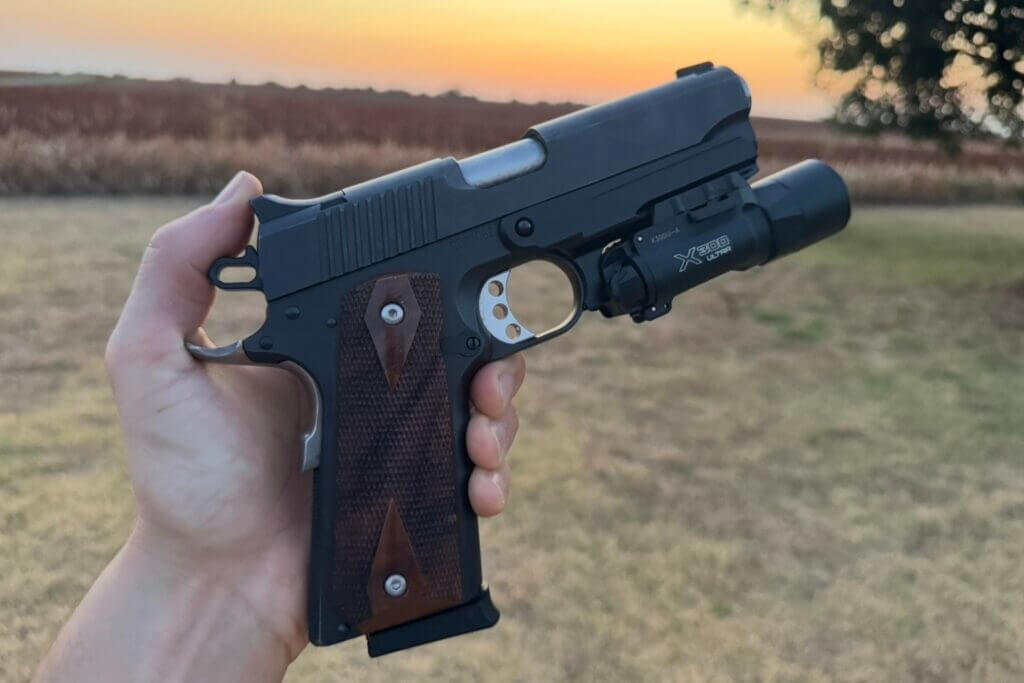 1911 pistol equipped with MisterSeven accessory rail and mounted weapon light