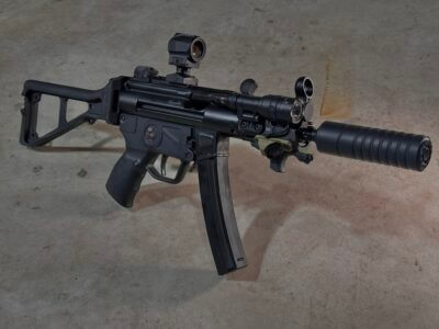 An MP5K is posed standing up on a concrete floor.
