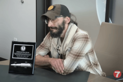 Jordan Salinas sits beside the silver bullet award recognizing his actions during the Twin Falls shooting